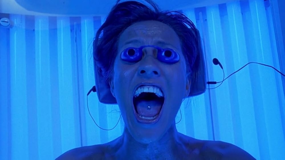 Person screaming inside a tanning bed, wearing protective eyewear, with a shocking expression. Scene evokes suspense and surprise