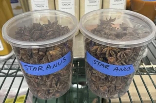 Two plastic containers on a shelf labeled with handwritten notes: "Star Anus," unintentionally humorous due to a spelling error