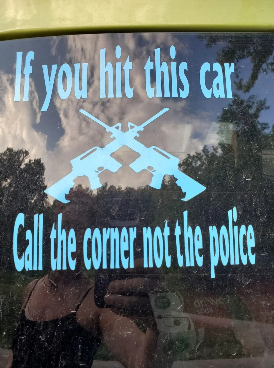 Car window sticker with crossed rifles says, "If you hit this car call the coroner not the police."