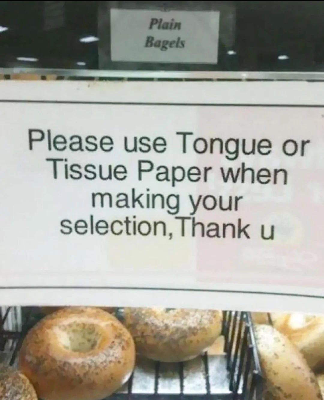 Sign near bagels reads, "Please use Tongue or Tissue Paper when making your selection, Thank u."