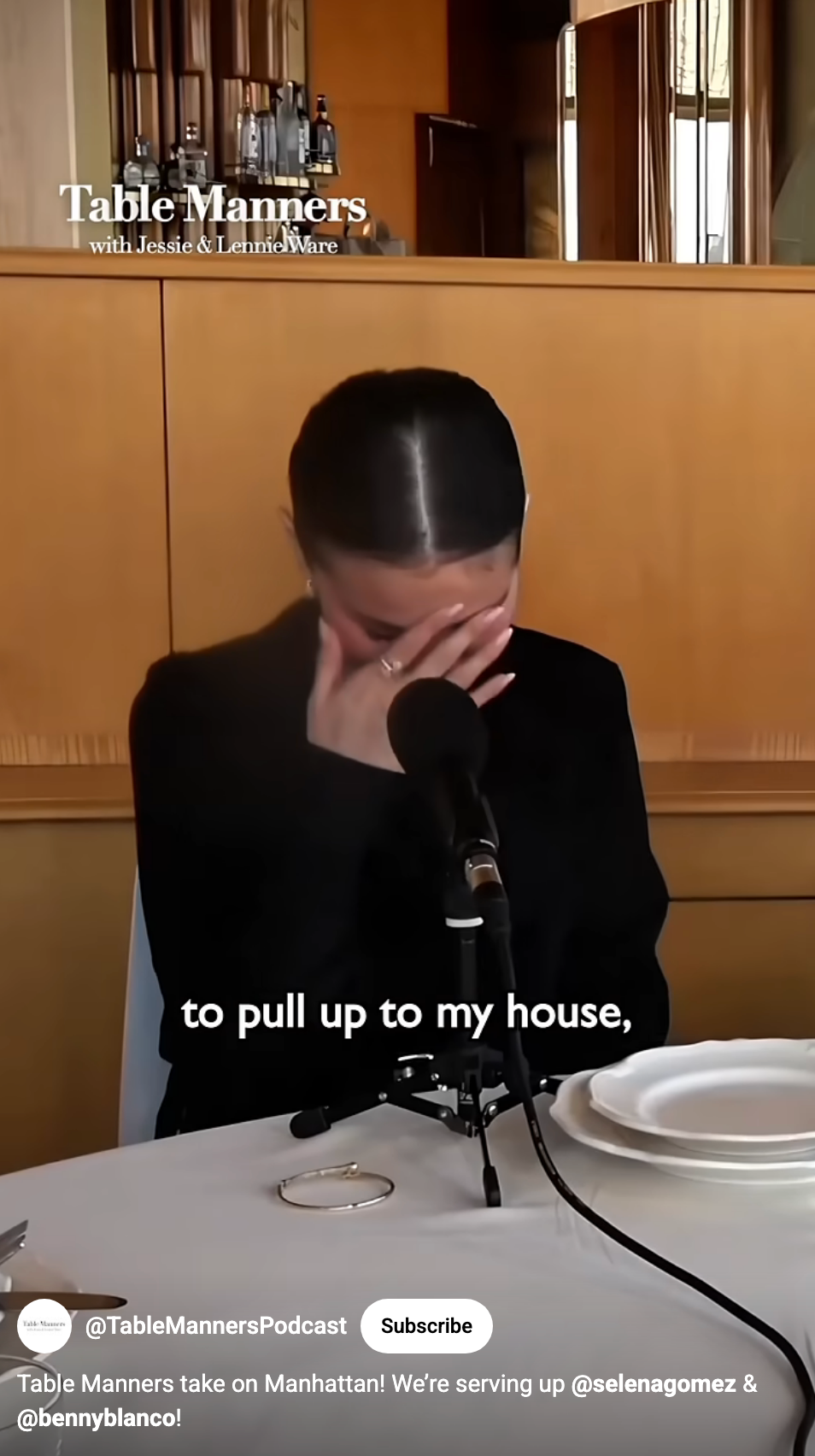 A person is sitting at a table with their hand partly covering their face in a restaurant setting, appearing to be on a podcast