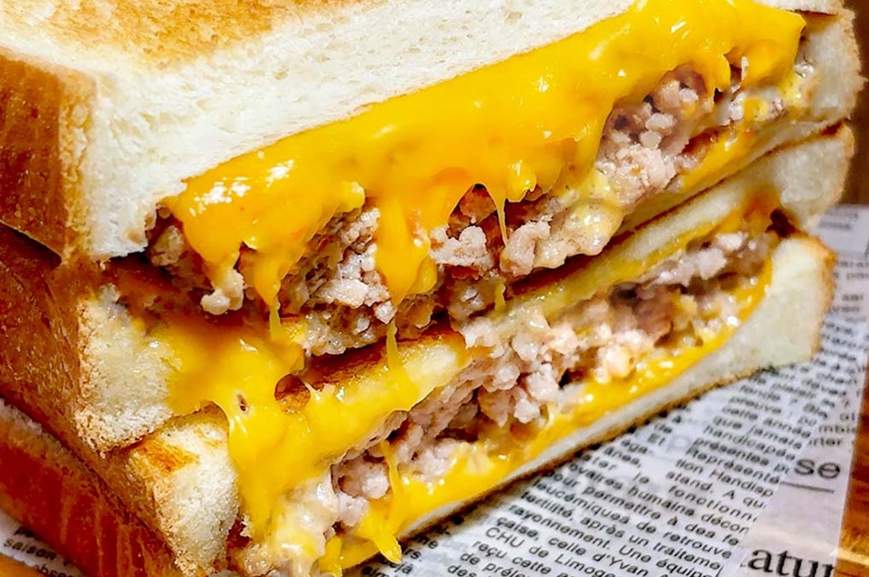 チーズが溶けたトーストサンドイッチの断面。中には挽き肉が詰まっている。背景には新聞紙が敷かれている。