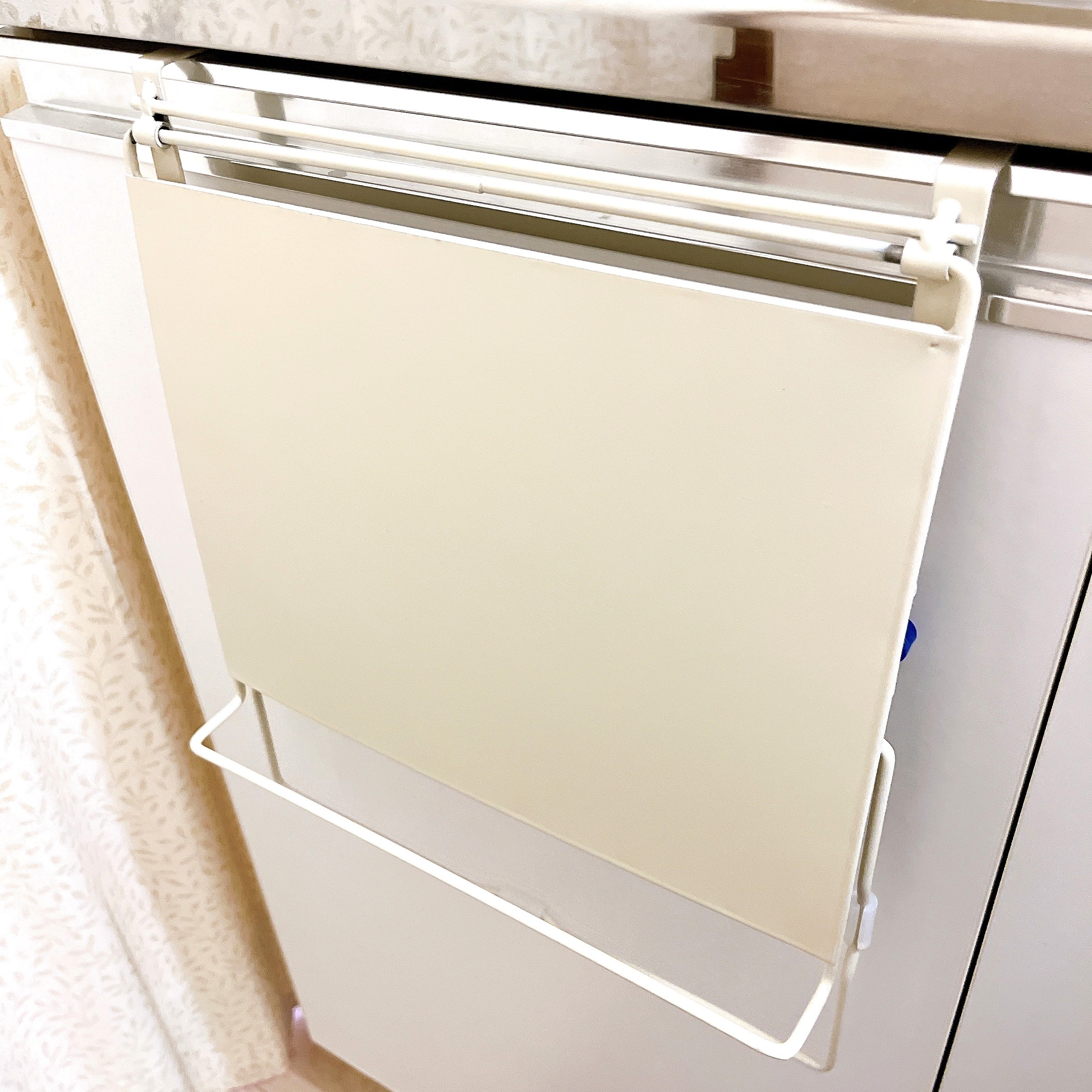 キッチンのキャビネットに取り付けられた、まな板ラックが写っています。