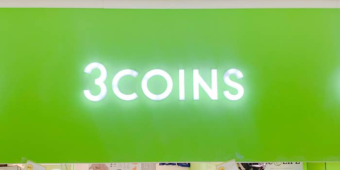 壁に「3COINS」と書かれたバックライトの看板。