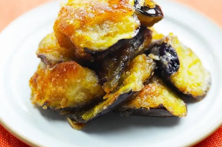 揚げたサツマイモチップスが白い皿に盛られている。サクサクした食感で、甘く美味しそう。