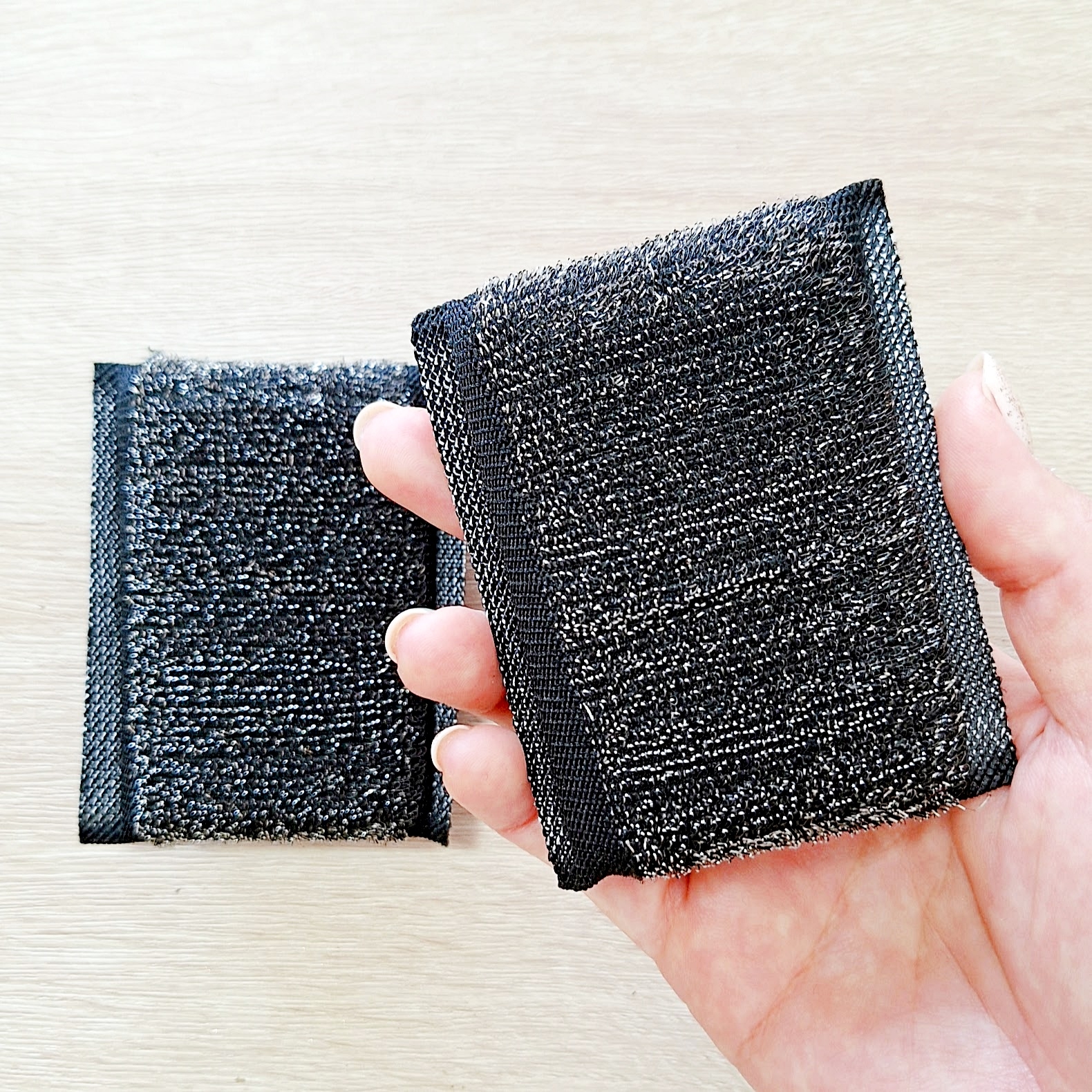 手に持った2つの掃除用のタワー。シンプルで実用的なデザイン。