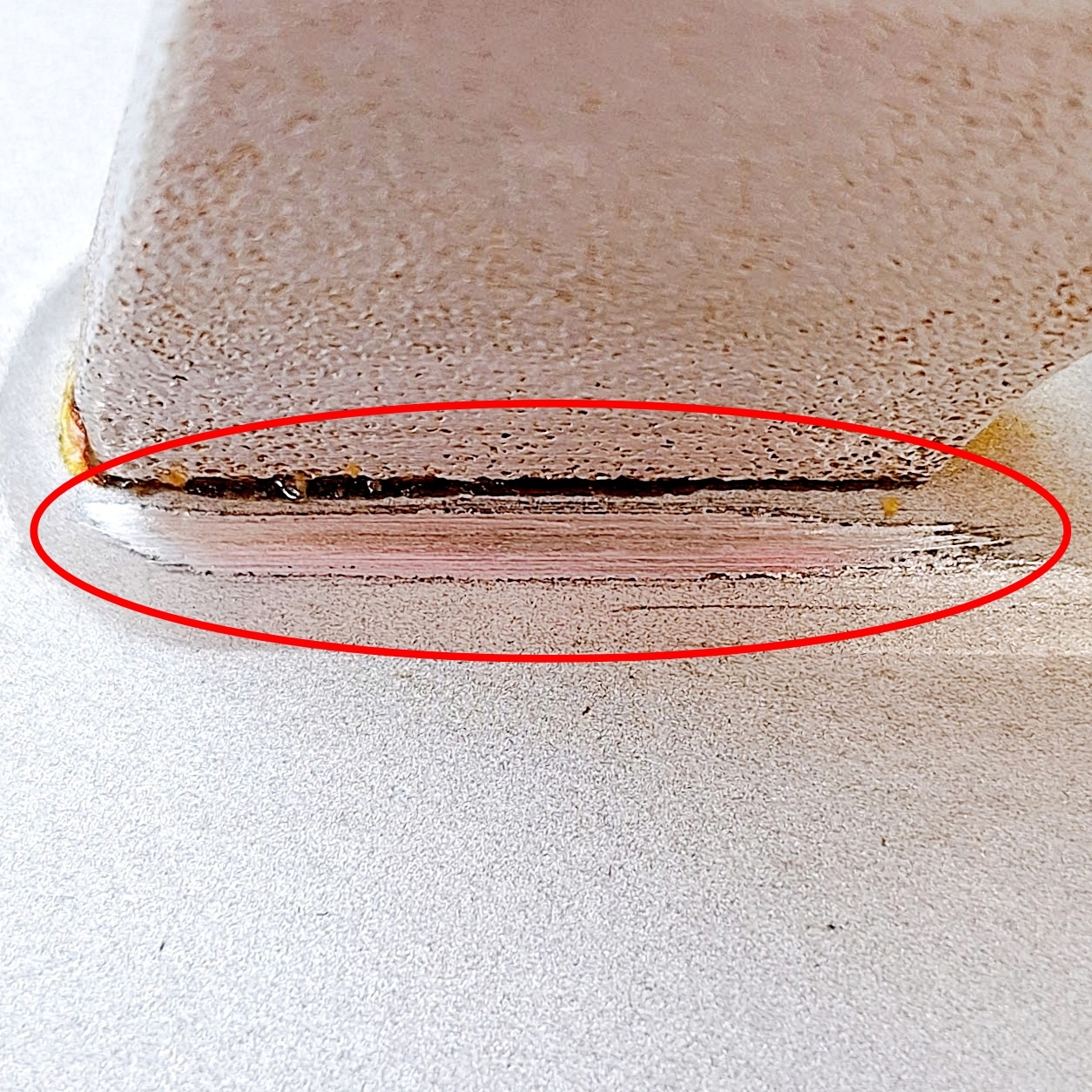 傷があるガラスの縁が赤い円で強調されています。