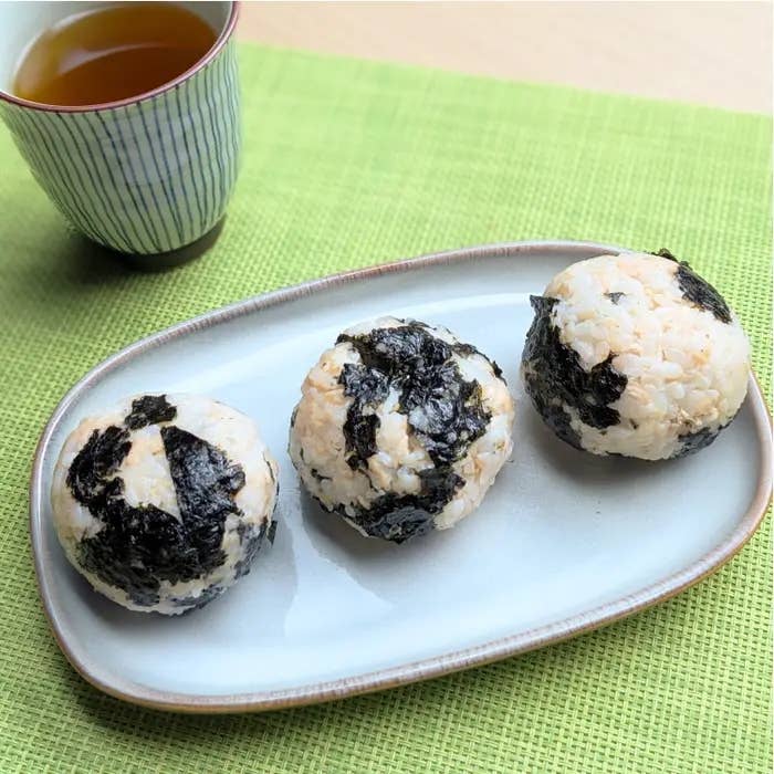 ツナマヨと韓国のりのおにぎりが3つ、白い皿に盛られ、