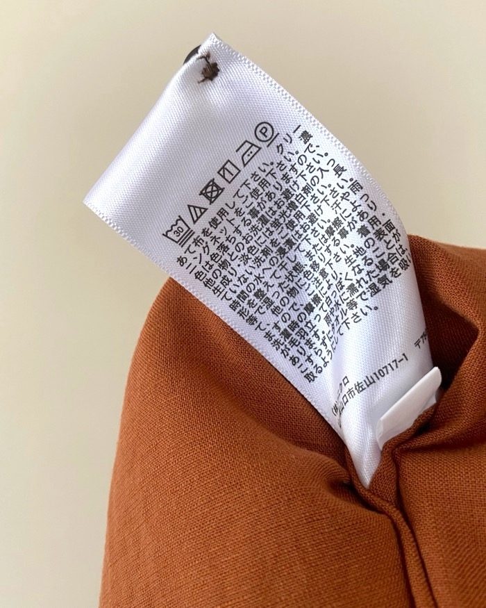 Clothing care label with care symbols and Japanese text on a fabric