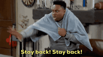 Person humorously wrapped in a blanket, extending an arm defensively, with text reading "Stay back! Stay back!"