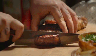 Person slicing a cooked meat roll on a cutting board, with herbs and other ingredients nearby. "#ChefMovie" text appears in the corner