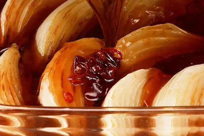 玉ねぎの輪切りにタレをかけている料理のクローズアップ。