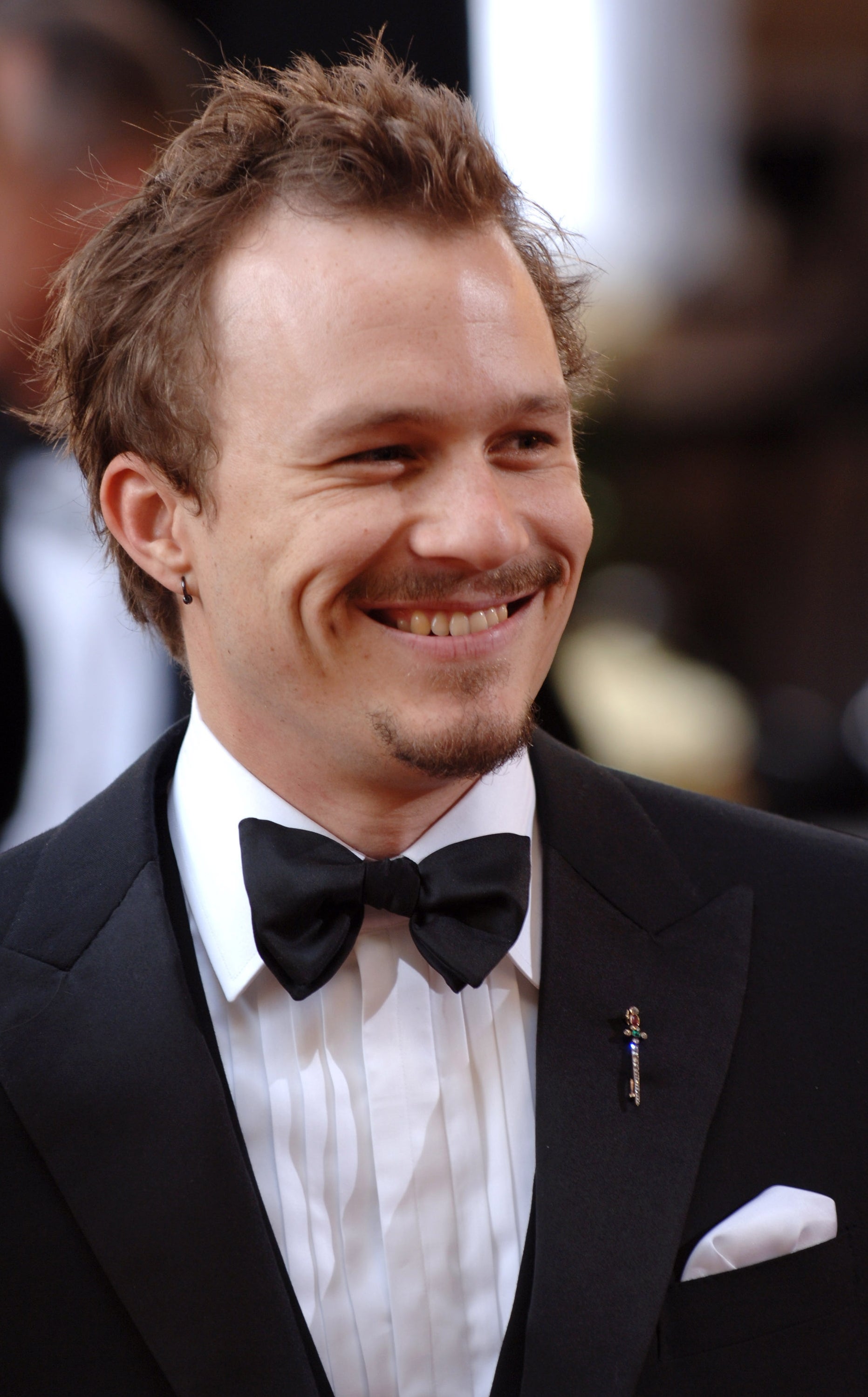 Heath Ledger smiling in a tuxedo at an event
