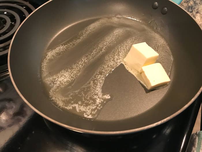 Butter melting in a frying pan on a stovetop