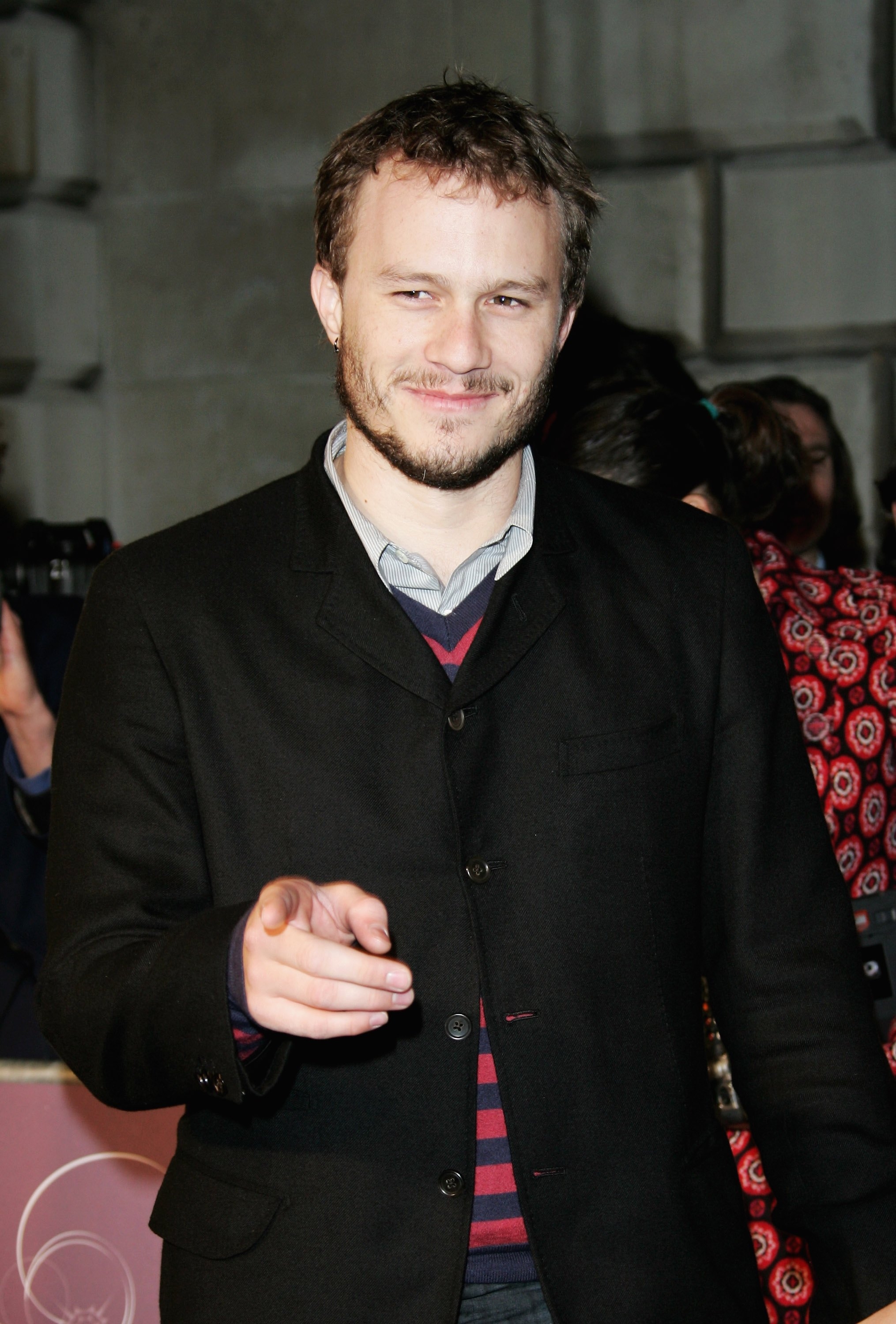 Heath Ledger smiling and pointing at the camera at an event
