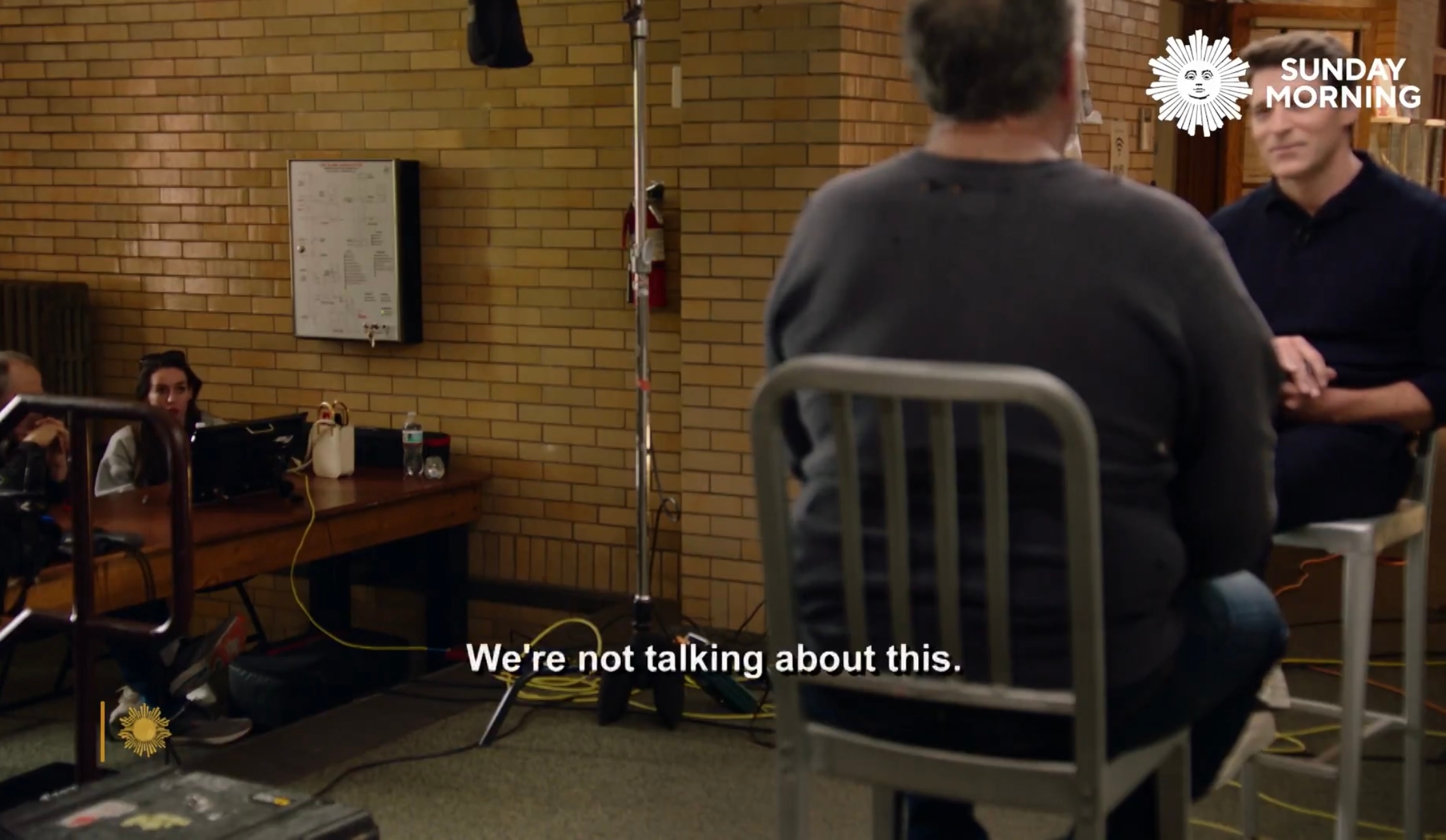 Jordon Hudson interjecting during a CBS interview. Subtitles read: &quot;We're not talking about this&quot;