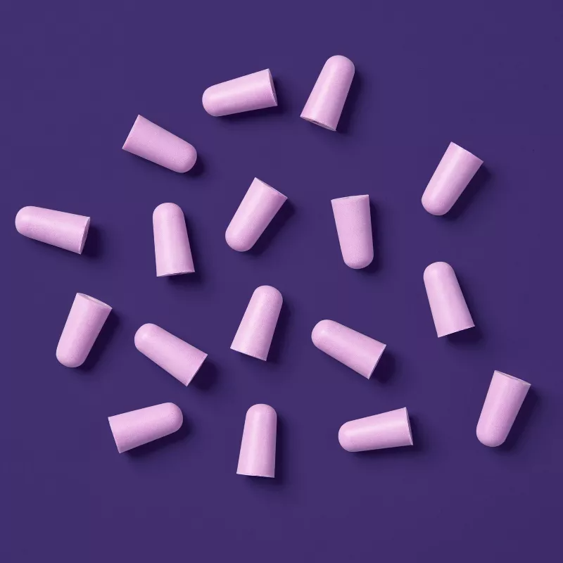 Pink earplugs arranged randomly on a solid background