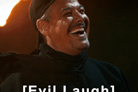 Smiling man in a backward cap laughs with "Evil Laugh" text overlay. Background features a flame