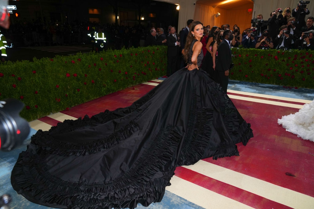 Kendall wearing a dark gown with a voluminous, sweeping train