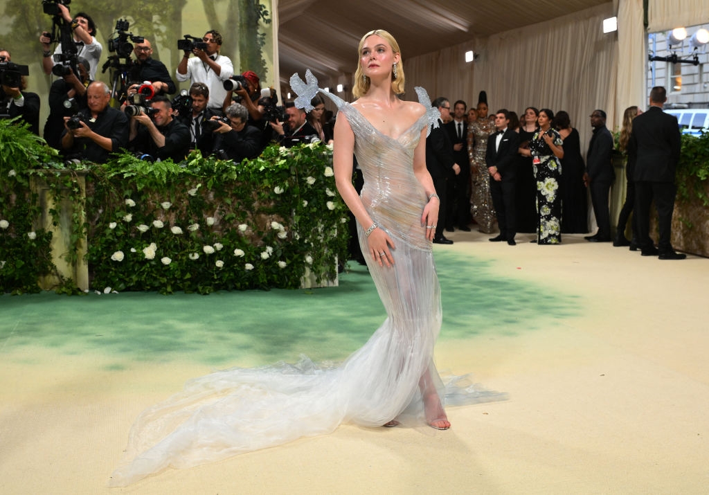 Elle in a flowing, sheer gown with glass-like flying bird features on the shoulders.