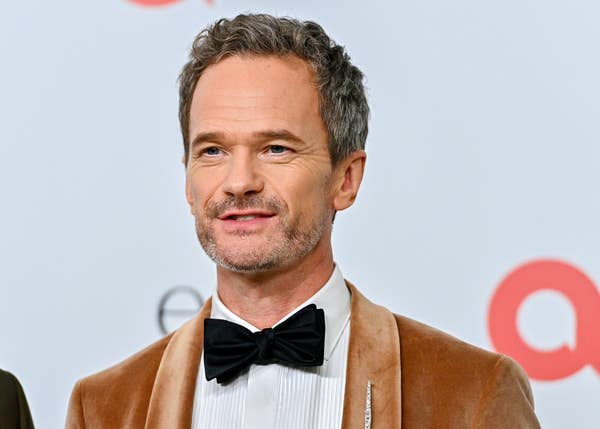Neil Patrick Harris in a velvet tuxedo and bow tie at a formal event, smiling