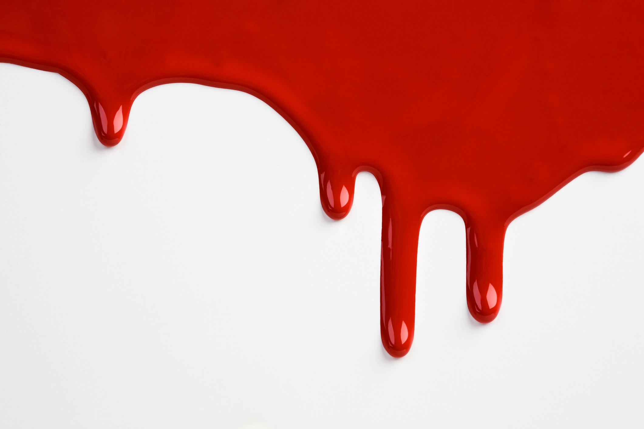 Red paint drips on a white surface, resembling blood, emphasizing a stark contrast