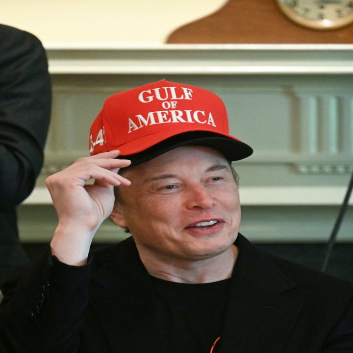 Person wearing a "Gulf of America" cap, smiling indoors, dressed in a dark outfit