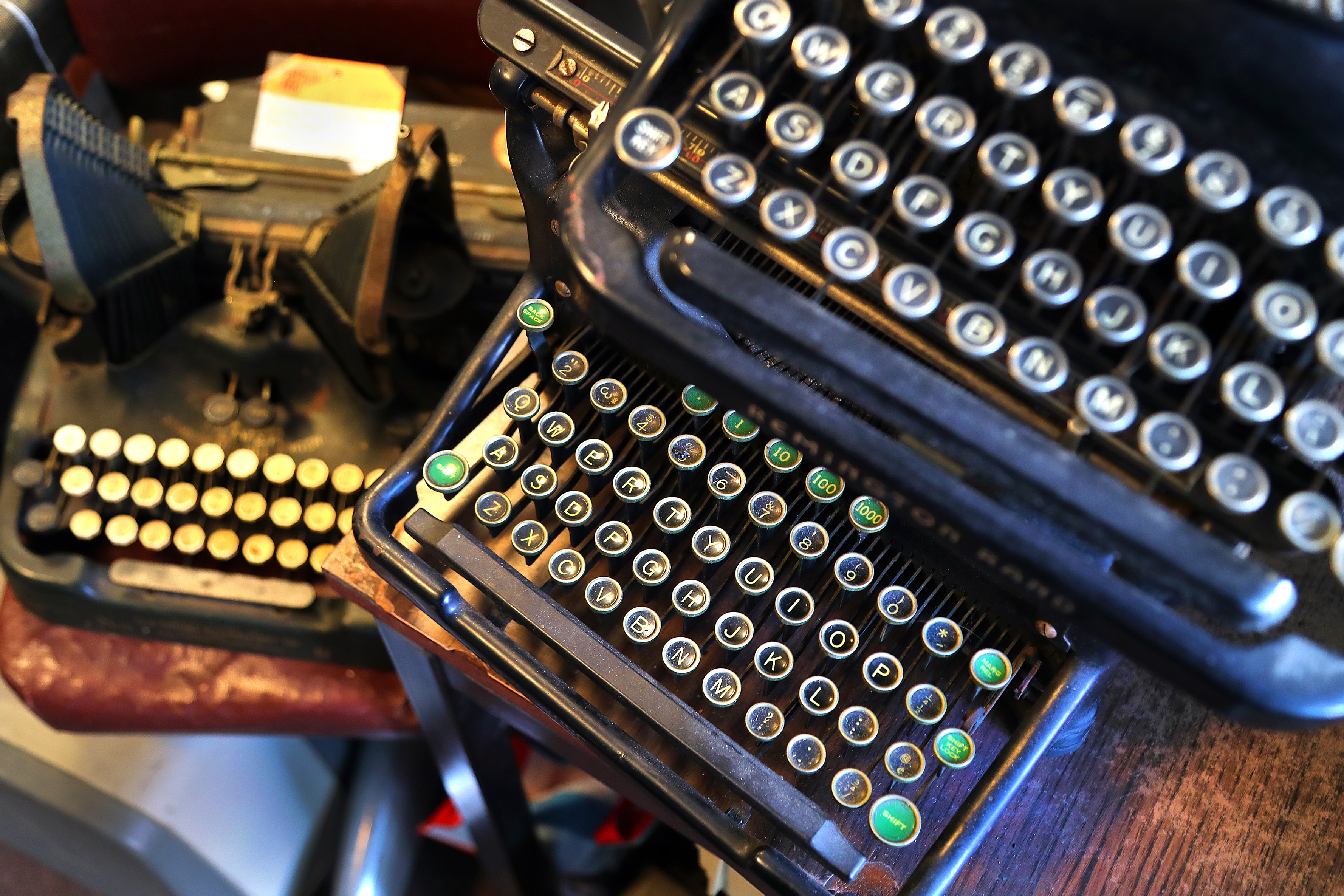 Close-up of two vintage typewriters with round keys arranged side by side, showcasing their intricate design and mechanical details