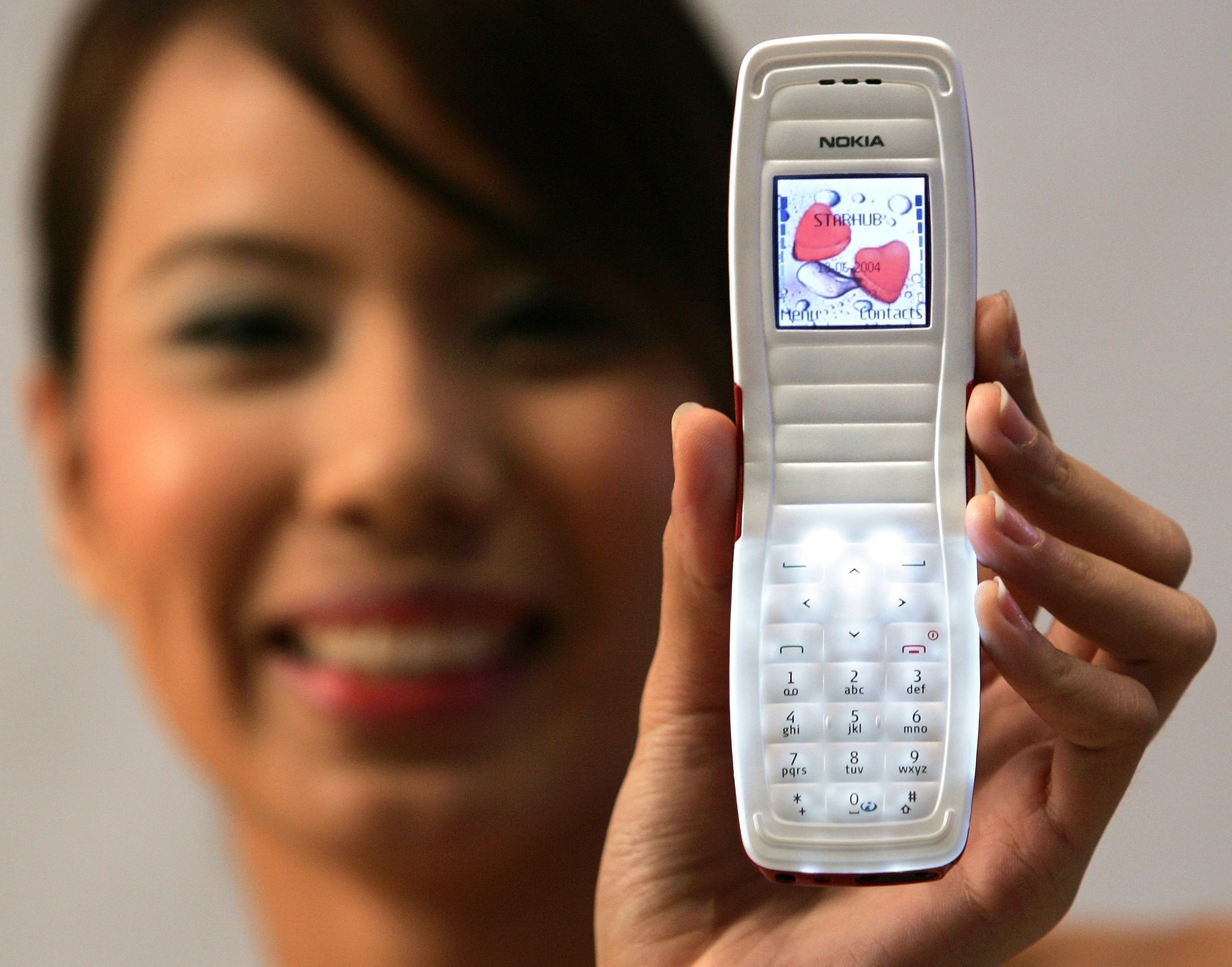 Person holding a Nokia phone with a display showing a heart image