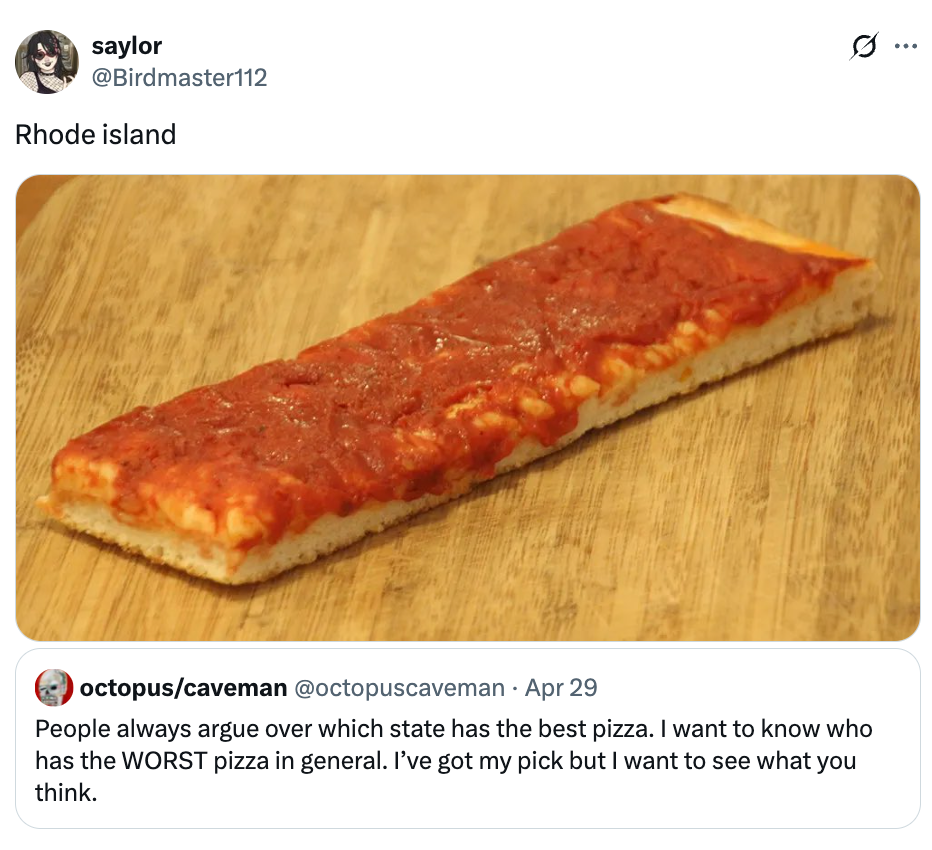 A rectangular piece of pizza with a thick crust and tomato sauce on a wooden surface