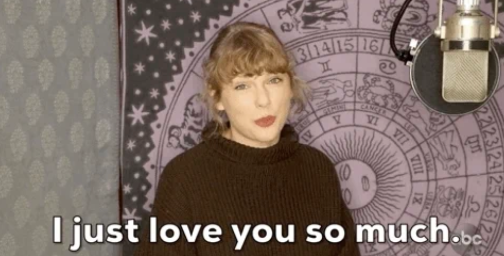 Person in a recording studio, wearing a cozy sweater, saying "I just love you so much." Tarot poster in background adds to intimate setting