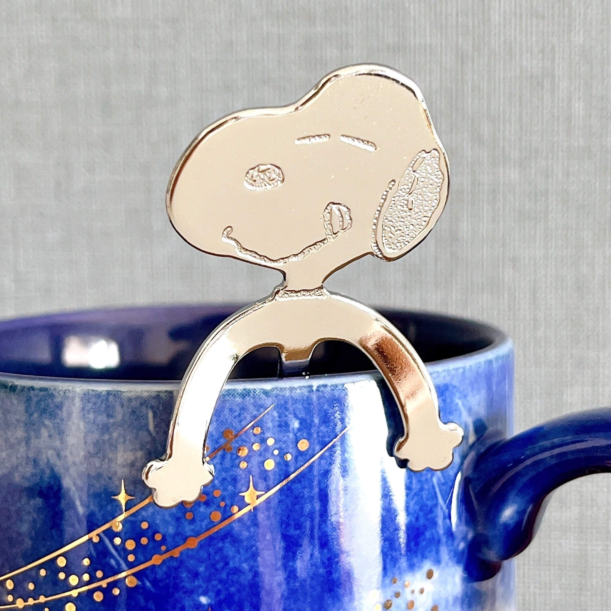 カップの端に、犬のキャラクターを模した金属製のティーホルダーが掛かっている。