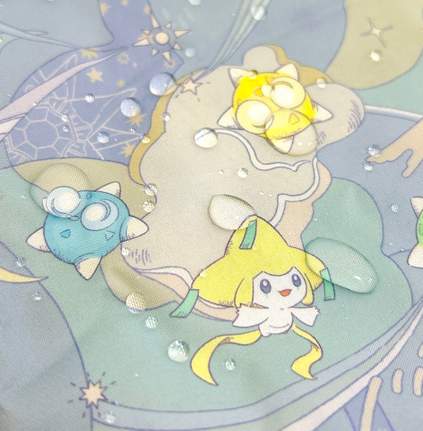 アニメキャラクターが水滴のある表面に描かれたグラフィック。楽しげな印象。