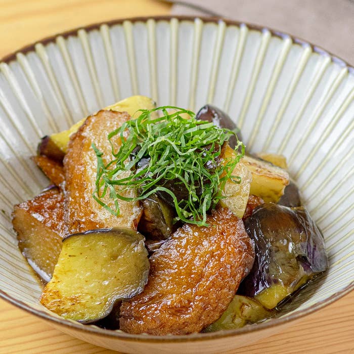 器に盛られたナスと油揚げの煮物。上に刻み青じそが添えられている。