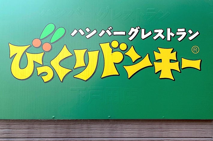 A green sign with bold, stylized Japanese text advertising a hamburger restaurant named &ldquo;Bikkuri Donkey.&quot;