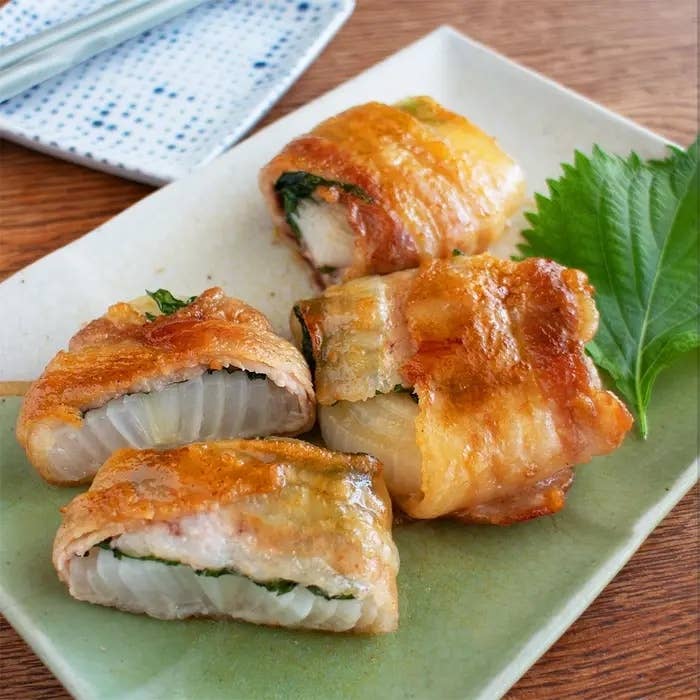 皿に盛られた美味しそうな肉巻き白菜。大葉が一緒に添えられており、食欲をそそる。