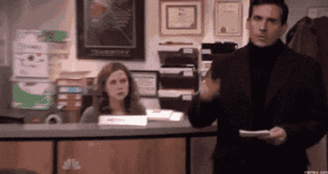A person in a suit confidently walks into an office, gestures dramatically, while a seated receptionist looks on in surprise
