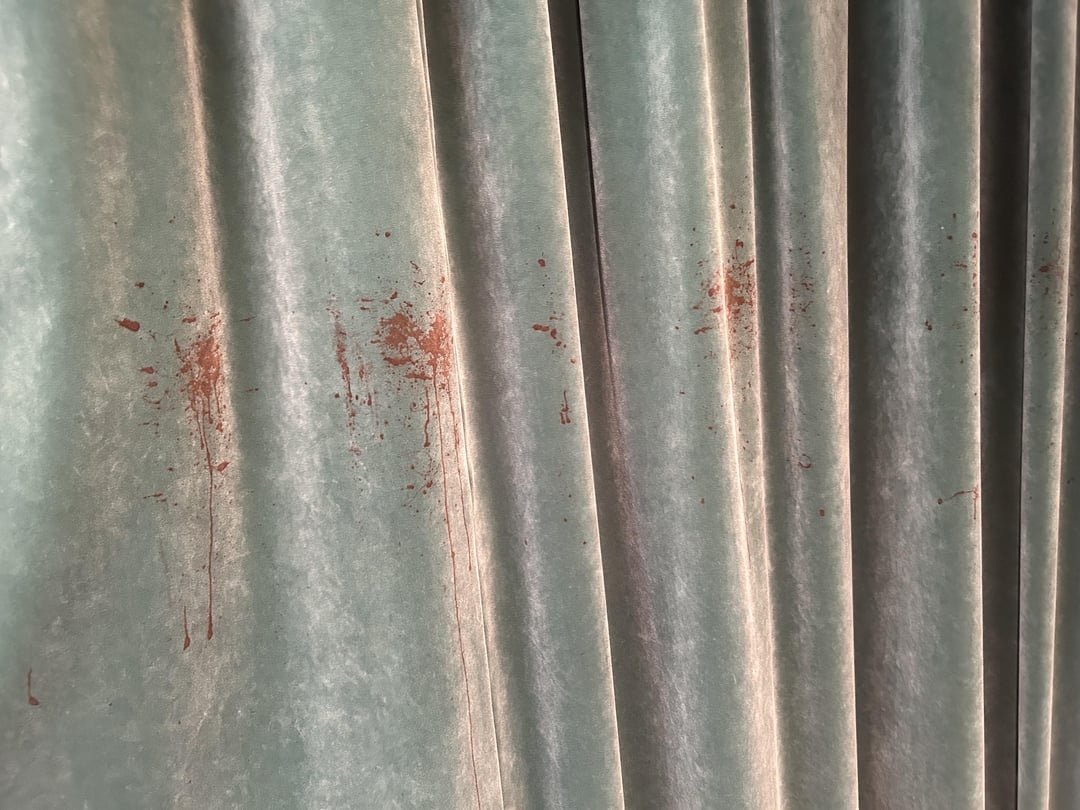 Curtains with noticeable stains, possibly from a liquid spill, creating a pattern across the fabric
