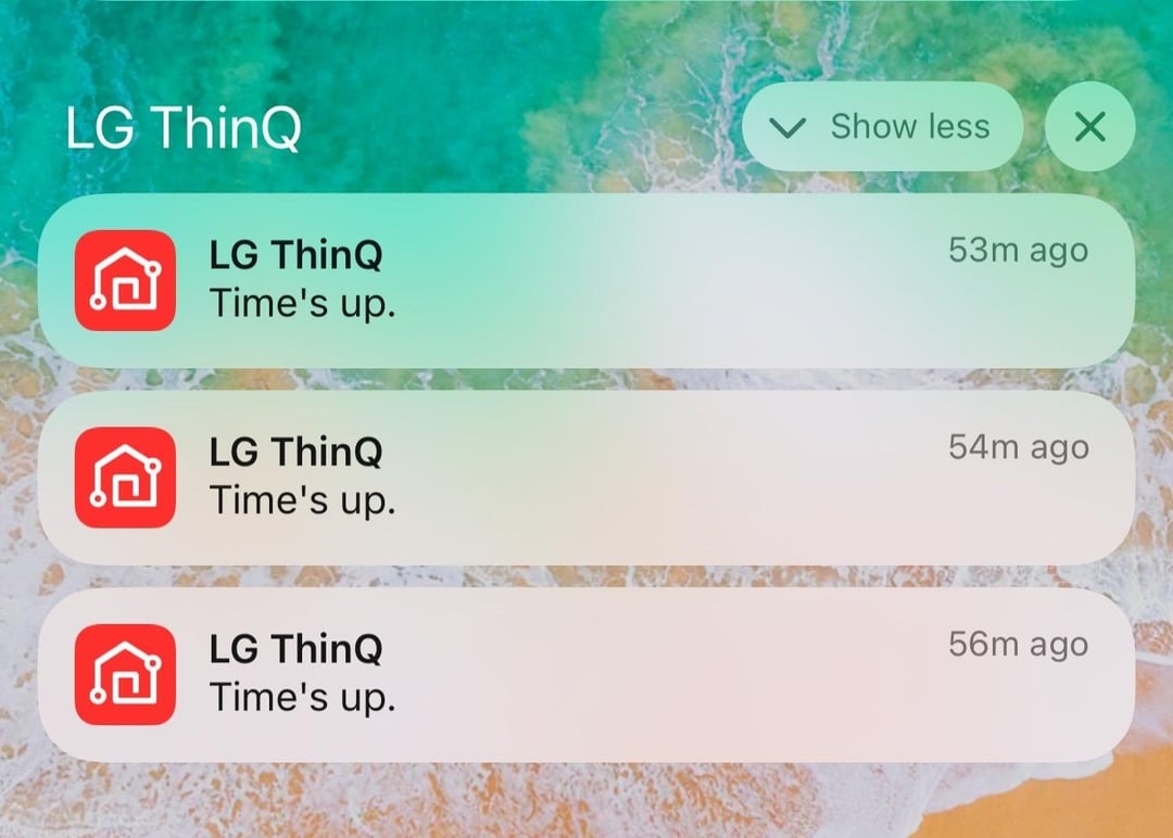 Three LG ThinQ notifications display "Time's up," received 53, 54, and 56 minutes ago. Background shows a beach shore