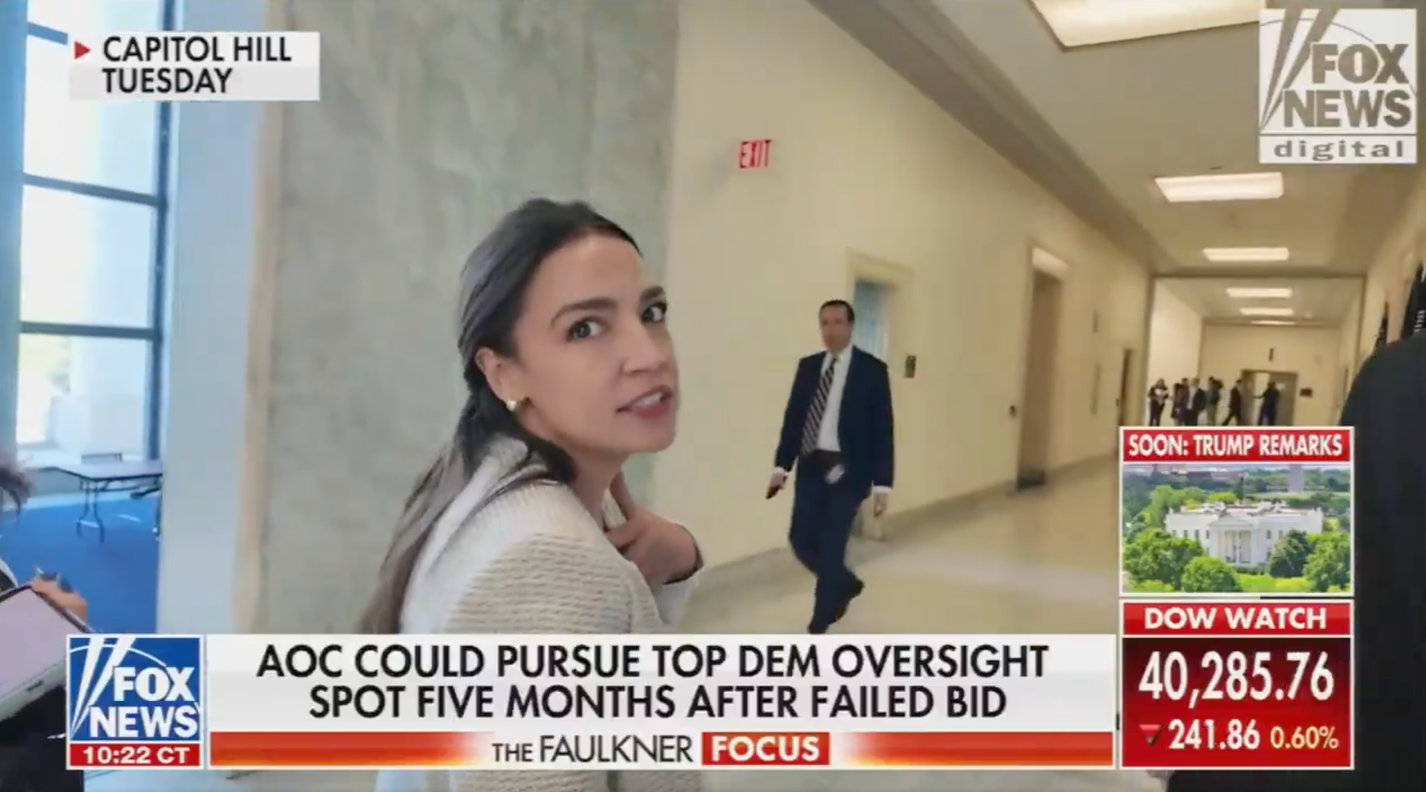 Woman in a hallway looks back; Fox News chyron discusses possible political pursuit after a failed bid