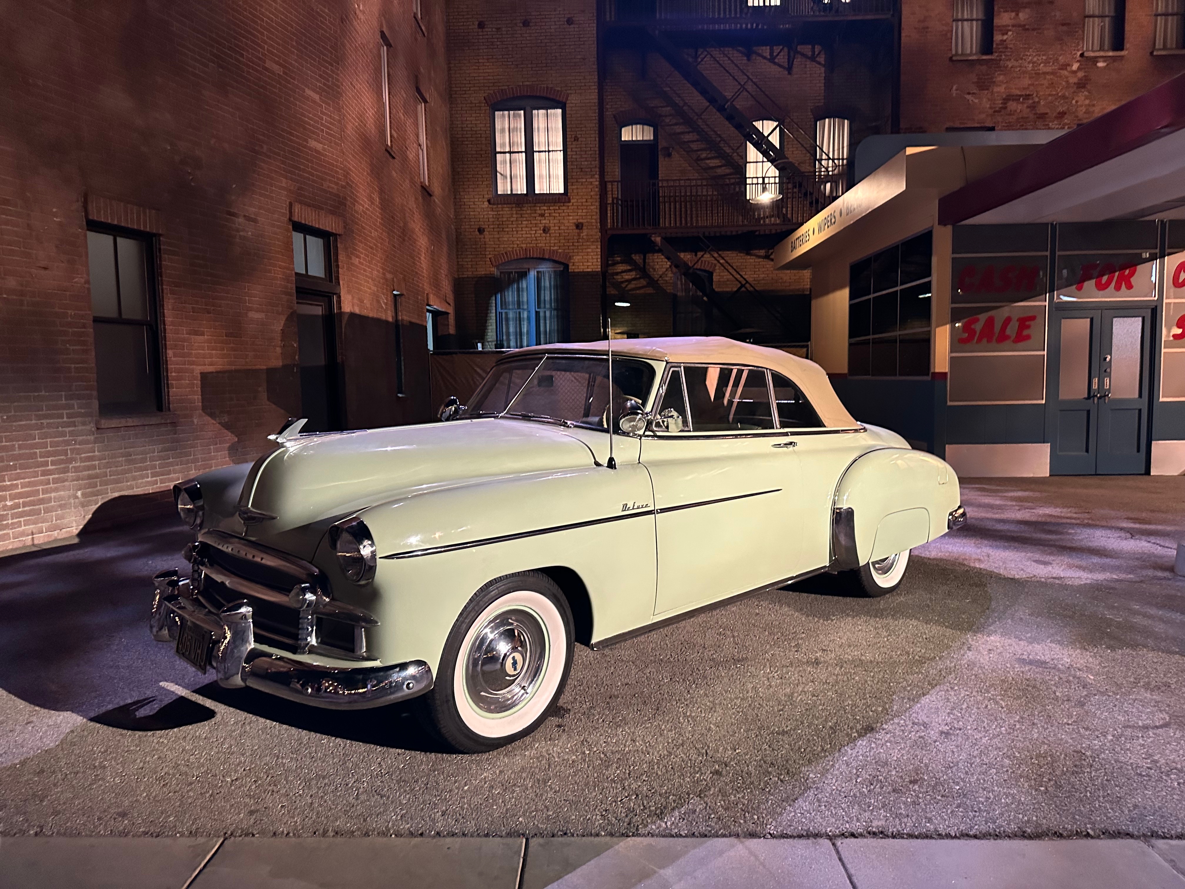 Classic convertible car parked on a street with vintage architecture in the background