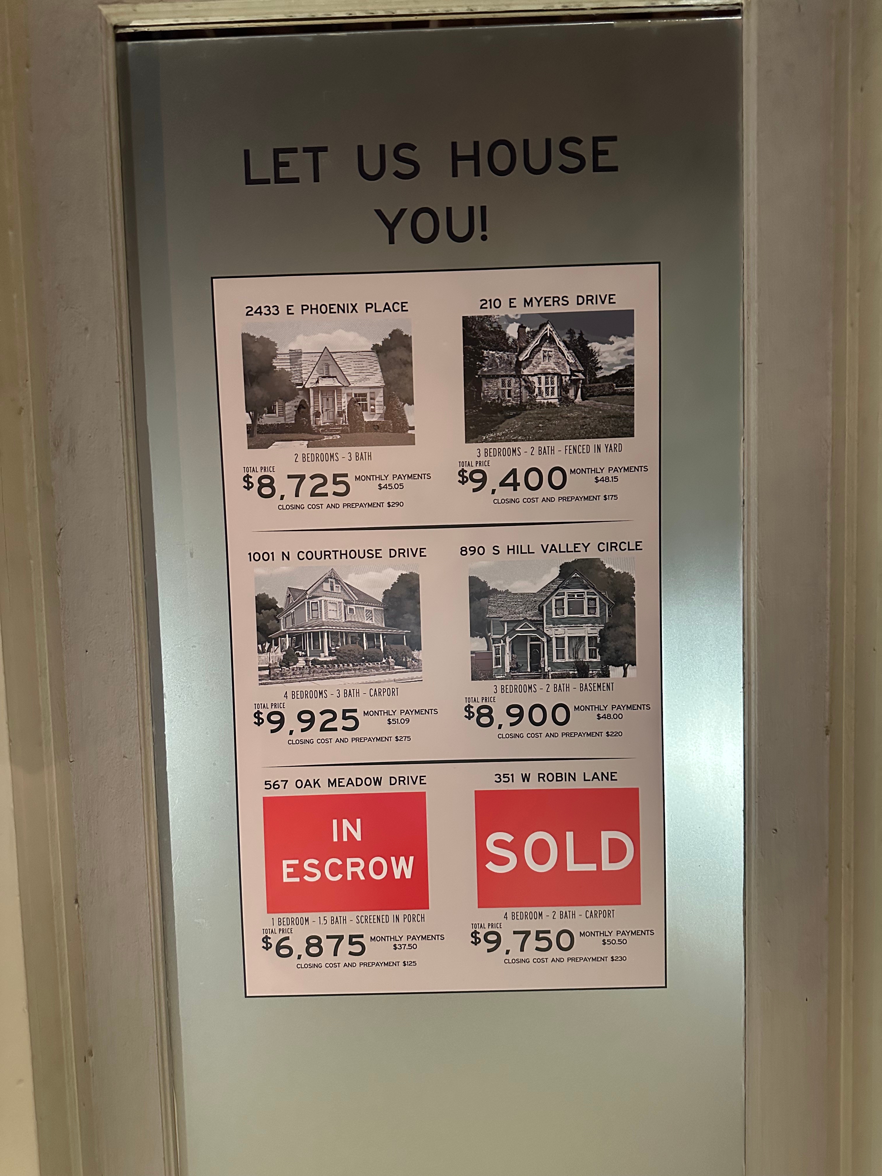 Real estate listings on a door showcasing house photos, prices, and sale statuses, with two labeled as &quot;In Escrow&quot; and &quot;Sold.&quot;