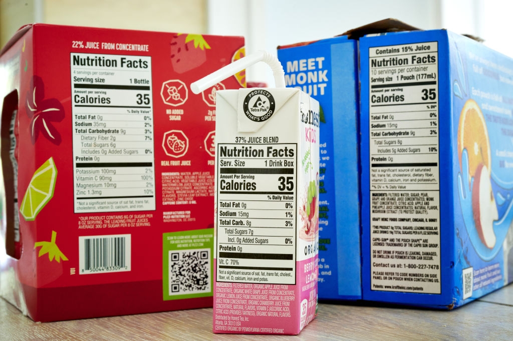 Assorterte juicebokser med synlige ernæringsetiketter som viser kalorier, ingredienser og serveringsstørrelser; Fokus på helsebevisste valg
