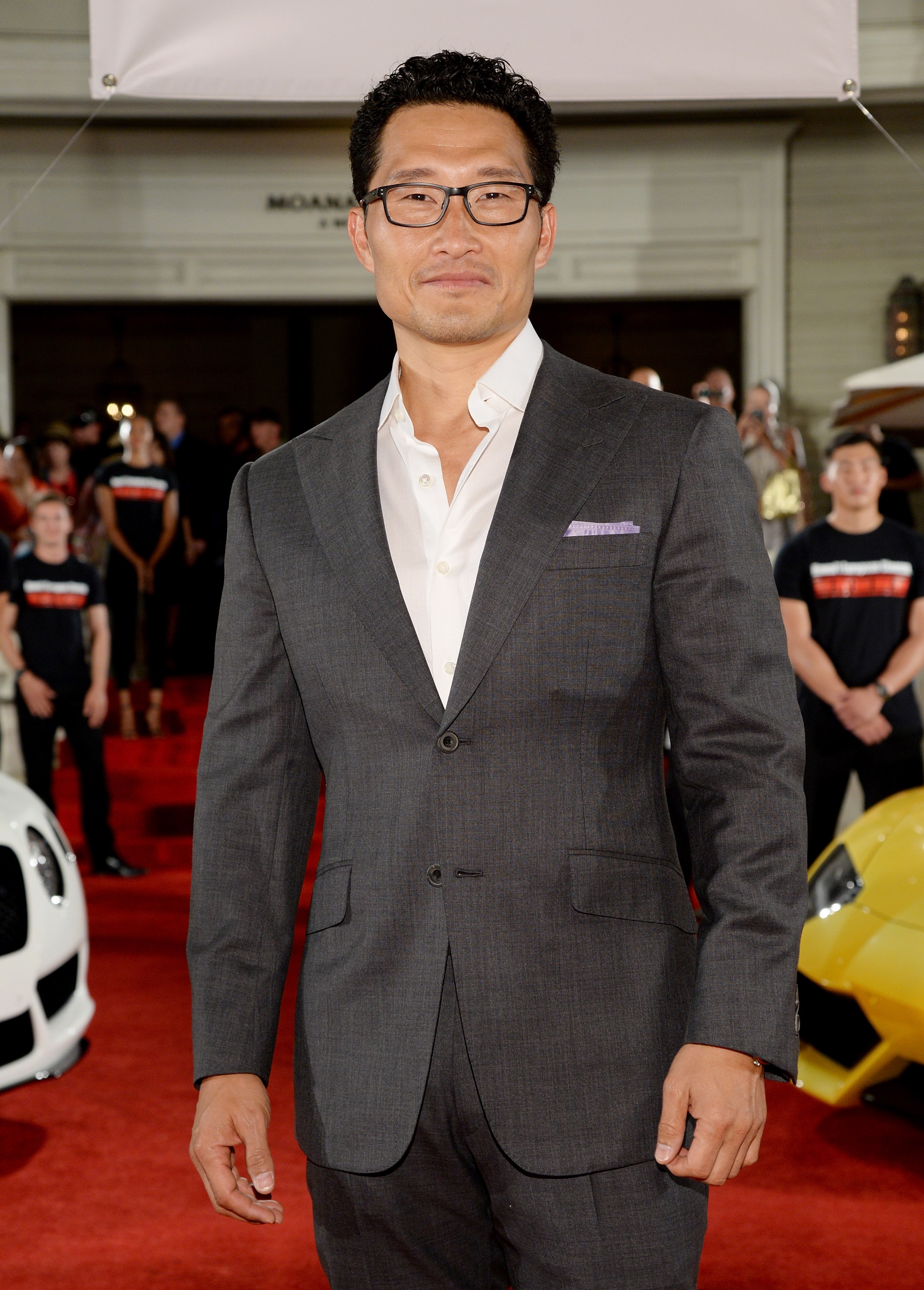 Daniel in a sharp suit on the red carpet, confidently posing for photos at a media event
