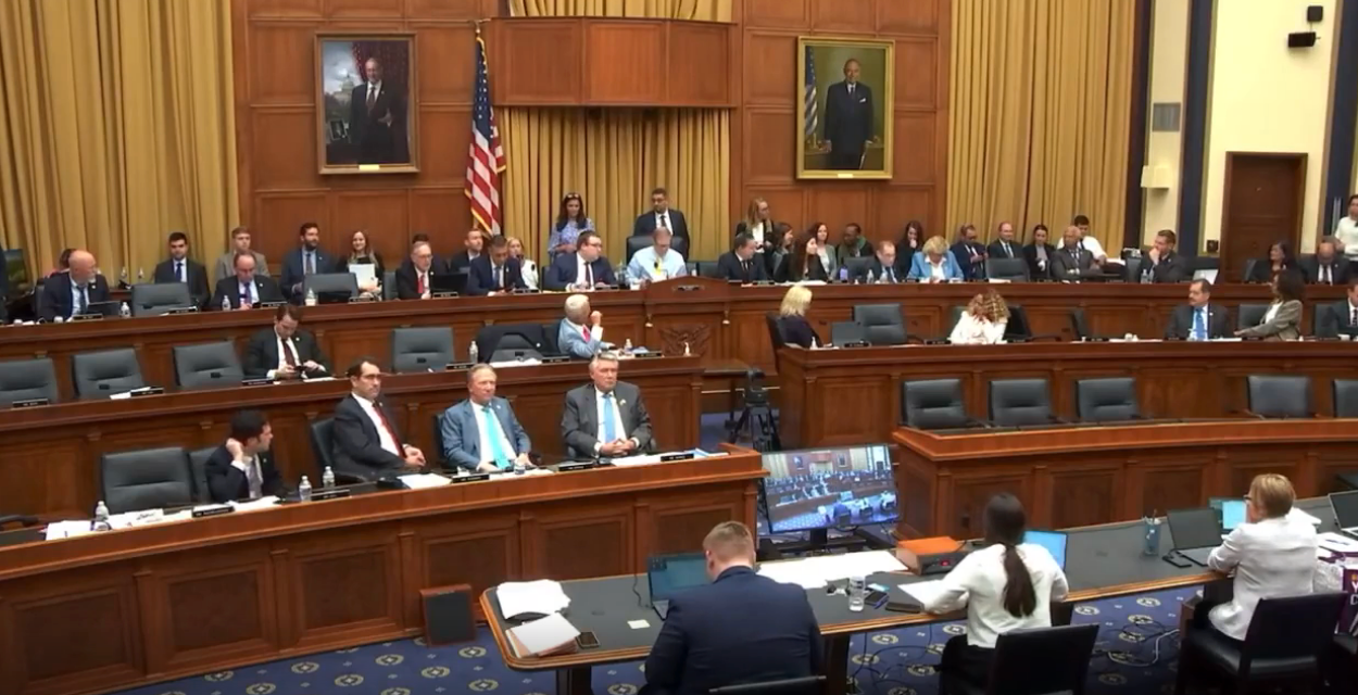 A congressional committee room with members sitting at desks