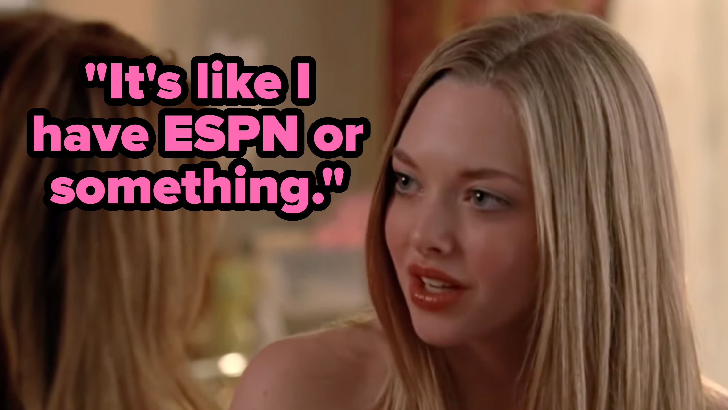 Two people in a conversation indoors, one facing the camera