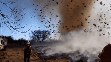 fire tornado with floating debris and dirt whirling in the air