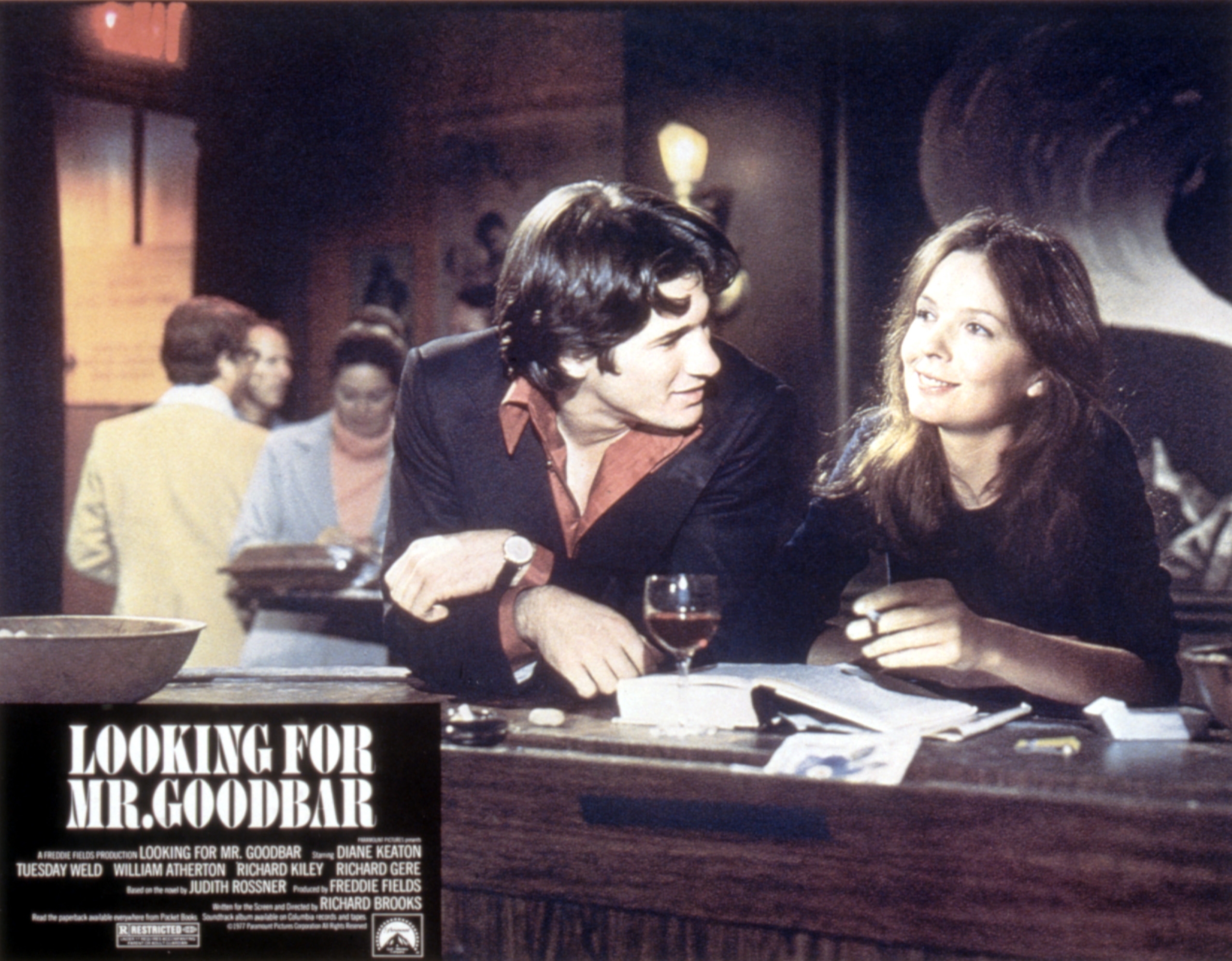Scene from "Looking for Mr. Goodbar": A man and woman converse at a bar, with first names, last names, and title on lower left.