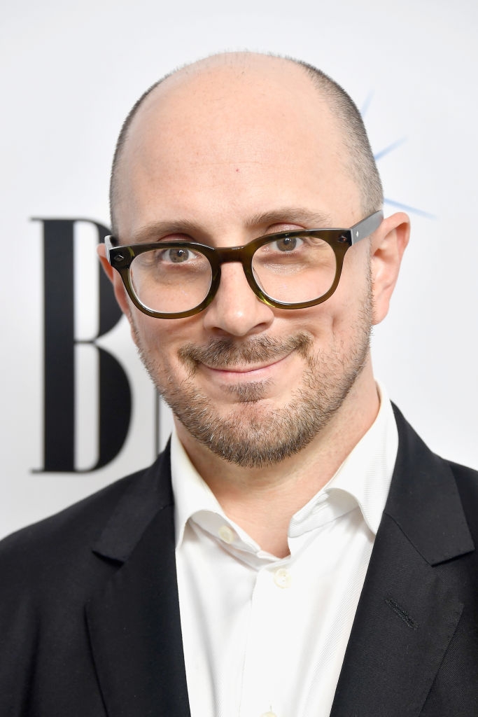 Man with glasses in a white shirt and dark blazer, attending a formal event