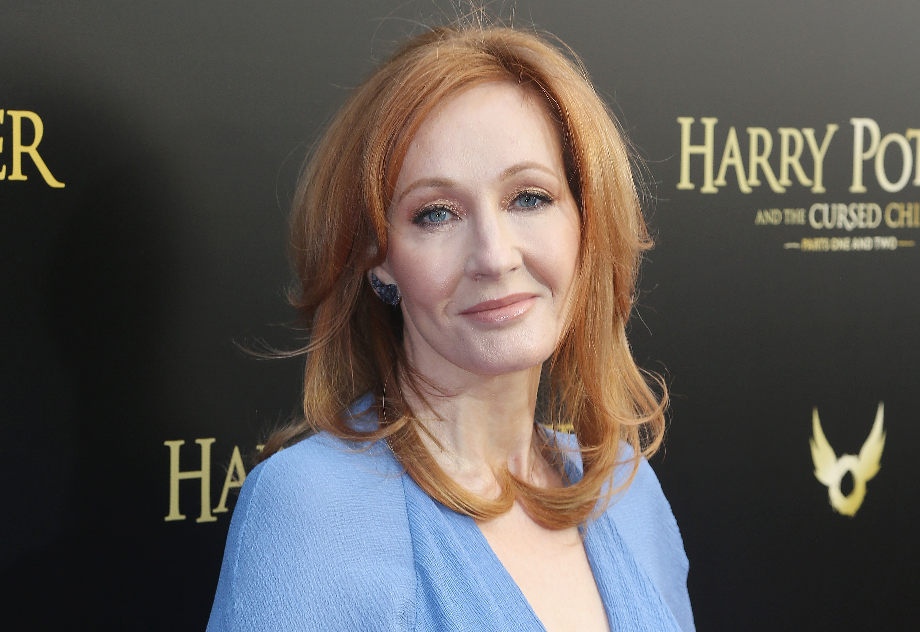 JK Rowling in a blue dress poses at a &quot;Harry Potter and the Cursed Child&quot; event